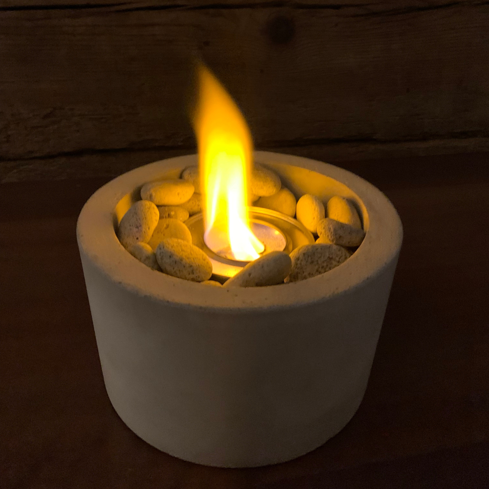 Fuego Interior Plantiviris — chimenea de concreto gris encendida para rituales de liberación